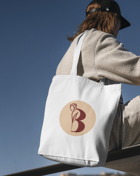 Sac en toile blanc avec un logo circulaire en rouge représentant une lettre B.