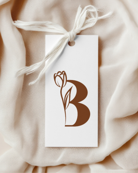 Étiquette blanche avec une fleur stylisée et la lettre "B" en marron.