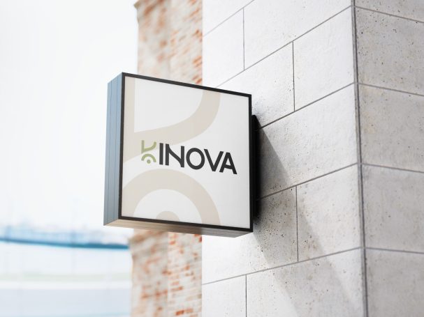 Panneau de magasin avec le logo "INOVA" sur un mur en briques.