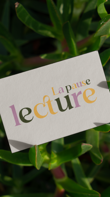Carte avec le mot "lecture" en lettres colorées sur fond de plantes vertes.