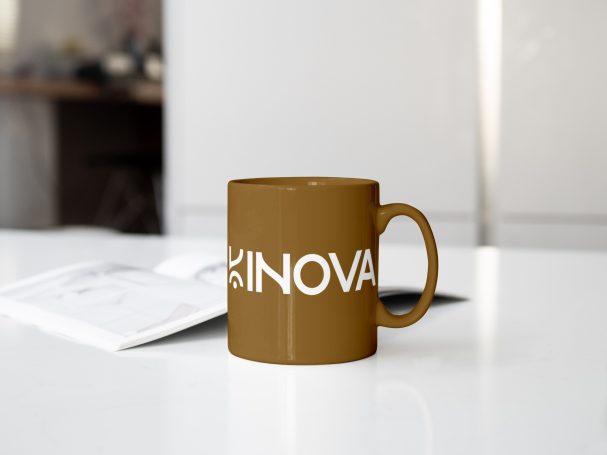 Tasse marron avec l'inscription "SINOVA" sur une table.
