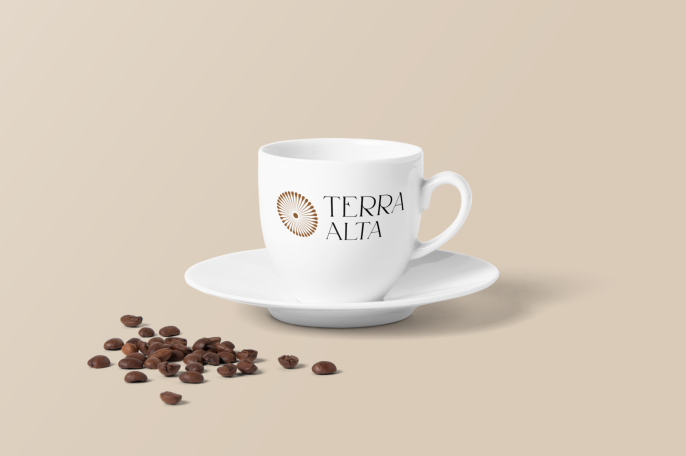 Tasse blanche avec logo "Terra Alta" et grains de café sur une soucoupe.