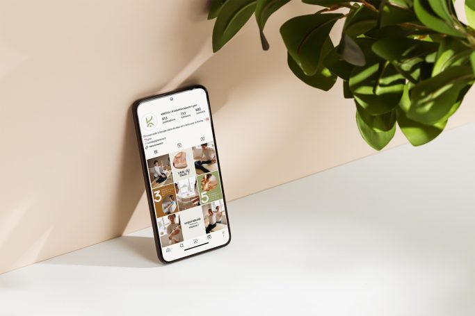 Un smartphone avec un écran affichant des images, entouré de plantes.