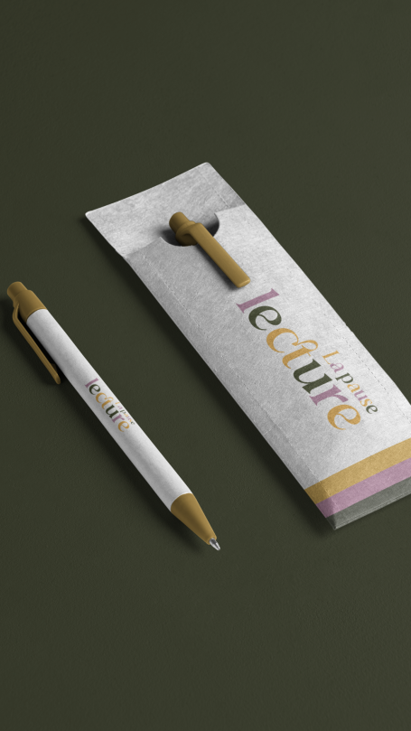 Stylo et marque-page sur fond uni, avec le mot « lecture » en lettre dorée.