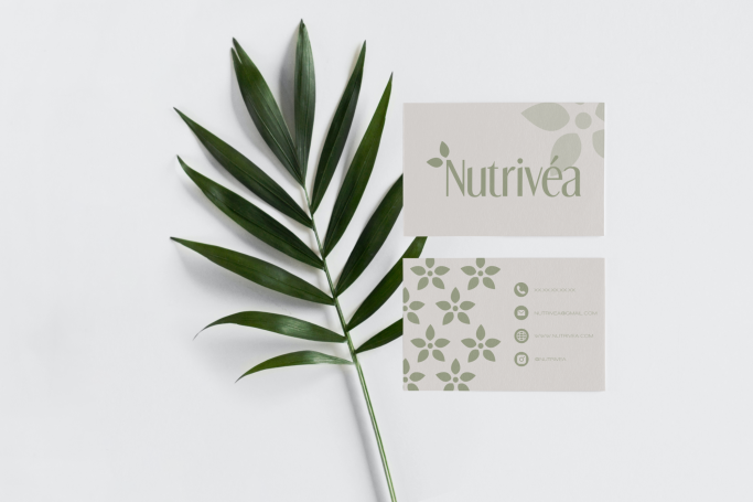 Une feuille verte avec des cartes de visite au design floral et minimaliste.