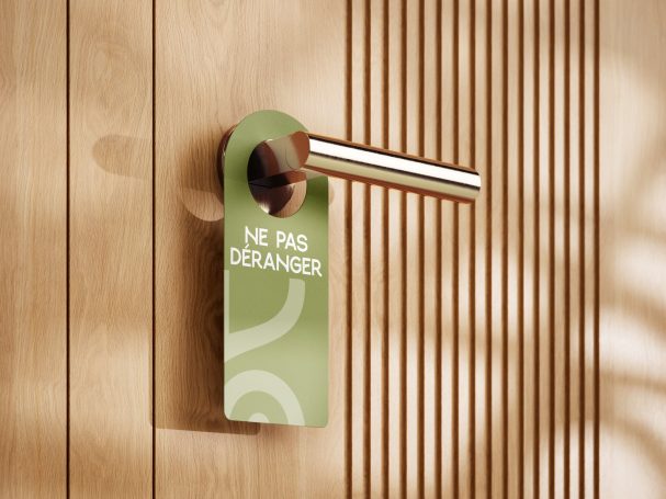 Panneau « Ne pas déranger » en bois sur une porte avec une poignée en métal.