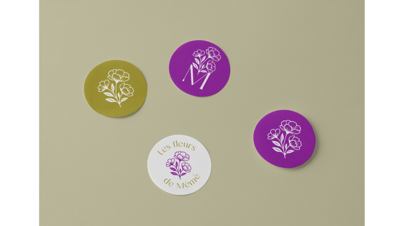 Quatre badges ronds de couleurs différentes avec des illustrations de fleurs.