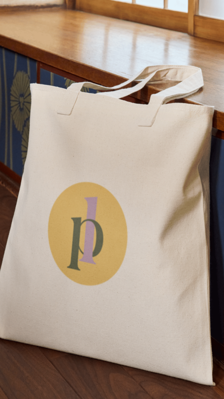 Sac en tissu beige avec un logo circulaire aux couleurs pastel.
