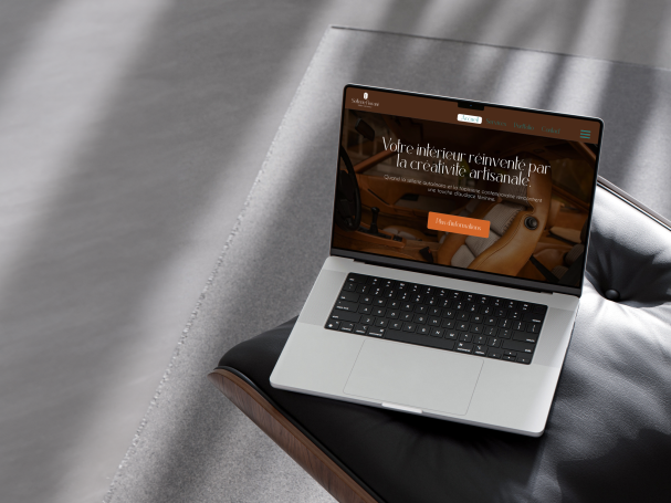 Ordinateur portable sur un canapé avec un site web affiché sur l'écran.